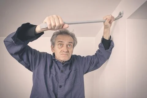 Man working on refresh of walls and ceiling before new painting of apartment Stock Photos