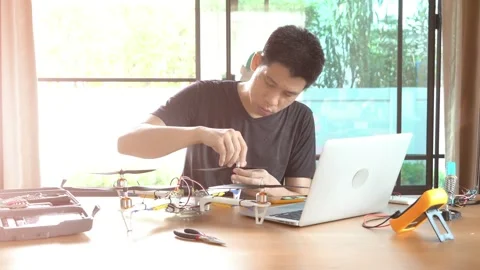 A man is working on a remote control drone on a table Stock Footage 315116538