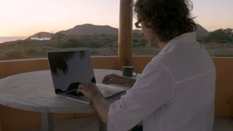 Man working from remote office along beach using smart phone and making call Stock Footage 80137496