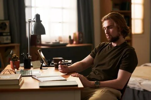 Man Working Remotely and Writing Notes in Home Office Stock Photos