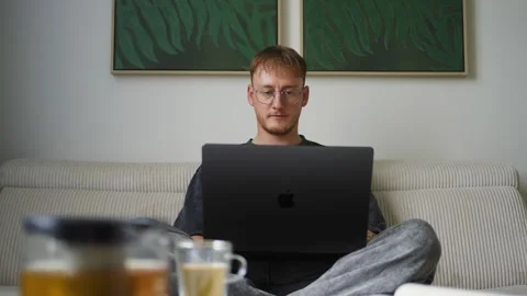 Man working remotely with laptop and tea Stock Footage 341669894