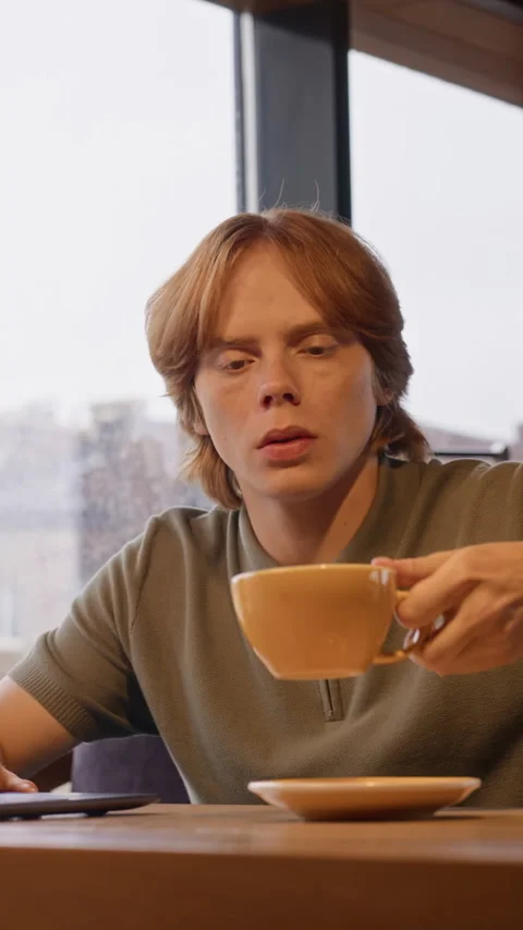 Man Working Remotely on Laptop and Drinking Coffee in Cafe Stock Footage 344365137