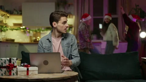 Man working remotely on laptop during New Year's Eve party at home Video stock 167553621