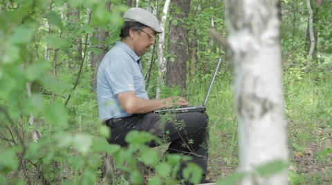 Man working remotely with laptop on the nature Stock Footage 63837200