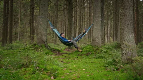 Man Working Remotely on Laptop While Lying in Hammock in Forest Stock Footage 348060892
