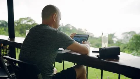 Man working remotely outdoors using tablet computer Фото