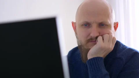 A man working remotely, working in front of a computer at home. A bald man with Stock Footage 170173558