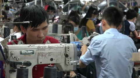 Man working on sewing machine in clothing factory in Vietnam Stock Footage 85863728