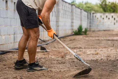 Man working with shovel on the ground, active man doing renovation and 库存照片