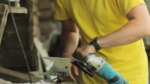 A man working on a smart watch, puts aside smartwatch and begins sawing metal Stock Footage 64999505