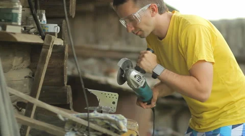 A man working on a smart watch, puts aside smartwatch and begins sawing metal Stock Footage 64999699