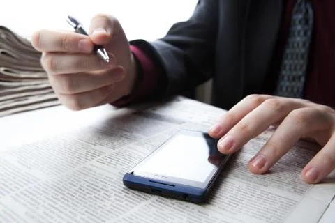 Man working on a smartphone in office Stock Photos