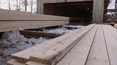 Man working at stacks of packed wooden planks stored in yard of sawmill Vídeo Stock 86012007