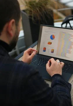 Man working with statistics on laptop Fotos de archivo