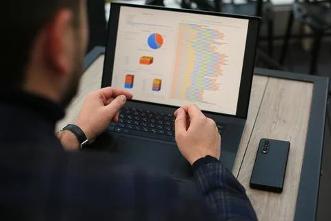 Man working with statistics on laptop Fotos Stock