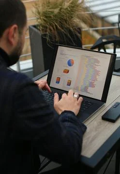 Man working with statistics on laptop Fotos Stock
