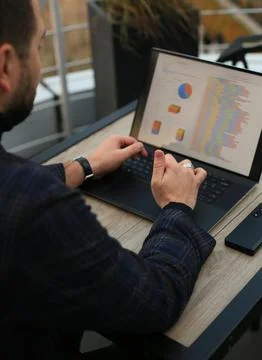 Man working with statistics on laptop Fotos Stock