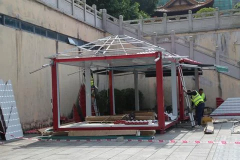 A man is working on a structure that is made of wood and metal Stock Photos