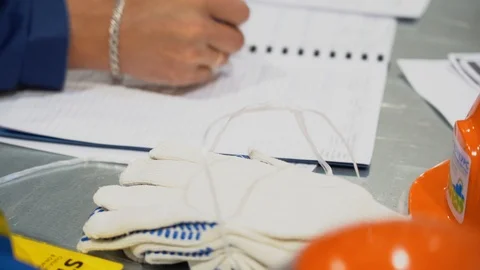 Man working on table, writing with ballpoint pen in logbook, sheets spread out Stock-Footage 126355639