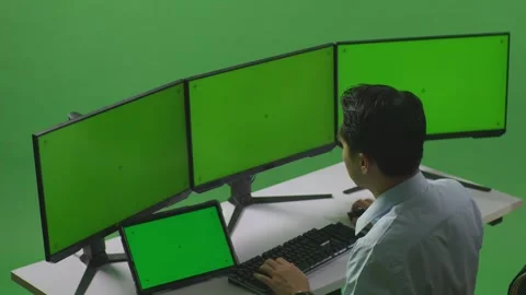 Man Working With Tablet And Multiple Computer Monitor With Mock Up Green Stock Footage 249634332