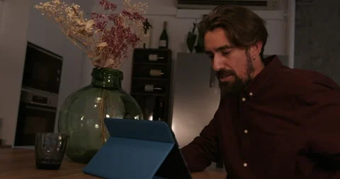 Man working on tablet in kitchen Stock Footage 194423187