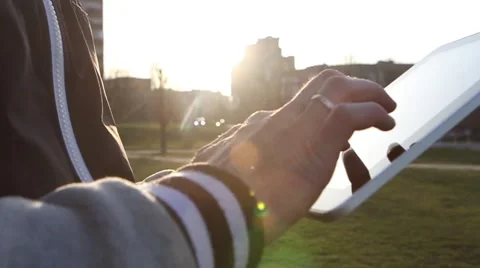Man Working on a Tablet on The Sunset Background Stockbeeldmateriaal 64873970