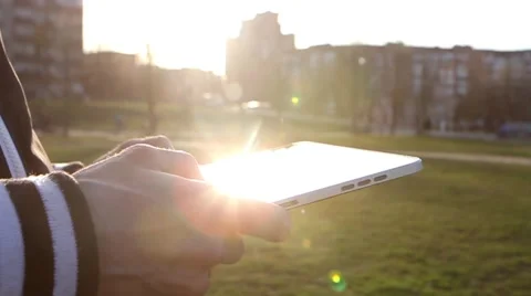 Man Working on a Tablet on The Sunset Background Stockbeeldmateriaal 64873974