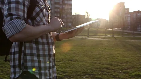 Man Working on a Tablet on The Sunset Background Stockbeeldmateriaal 64873975