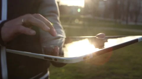 Man Working on a Tablet on The Sunset Background Stockbeeldmateriaal 64873985