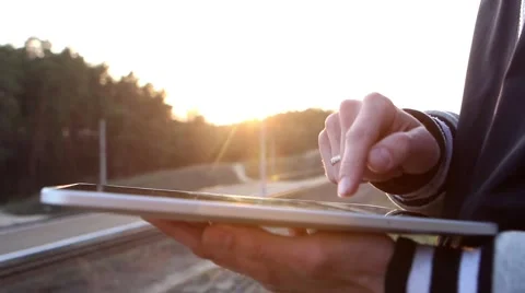 Man Working on a Tablet on The Sunset Background Stockbeeldmateriaal 64874044