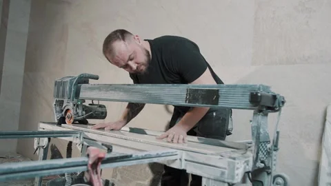 Man working on tile installation using tools in a workshop setting Video stock 317378264