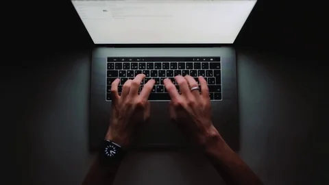 Man is working typing use laptop computer at home office at dark night Stock Footage