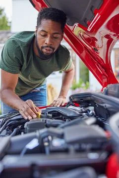 Man Working Under Hood Checking Car Engine Oil Level On Dipstick Stock Photos