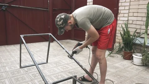 A man in a working uniform and gloves with a drill in his hands Vidéo 145395017