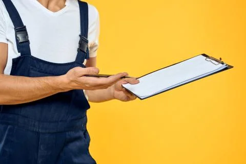 Man in working uniform documents rendering of services delivery service yellow Stock Photos