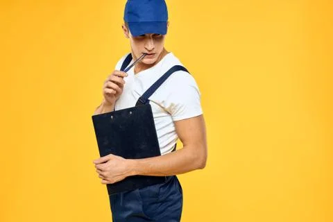 Man in working uniform documents rendering of services delivery service yellow Stock Photos