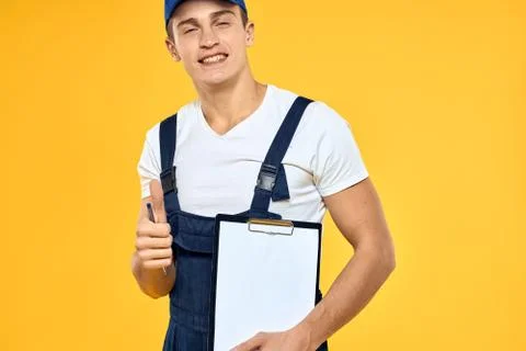 Man in working uniform documents rendering of services delivery service yellow Stock Photos