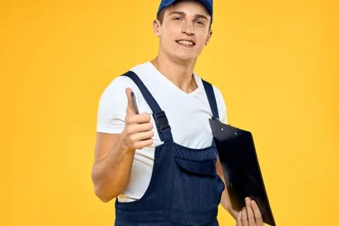 Man in working uniform documents rendering of services delivery service yellow Stock Photos