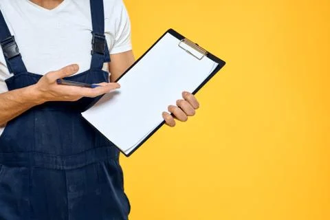 Man in working uniform documents rendering of services delivery service yellow Stock Photos