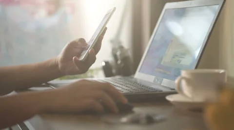 A man is working by using a laptop computer and a smartphone Stock Footage 60913086