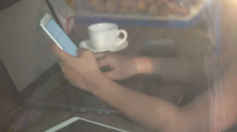 A man is working by using a laptop computer and a smartphone on wooden table. Stock Footage 60943168