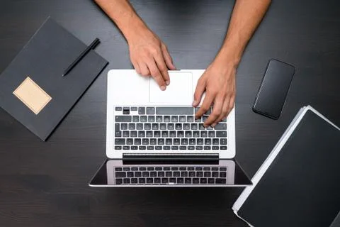 A man is working by using a laptop computer on vintage wooden table Foto stock