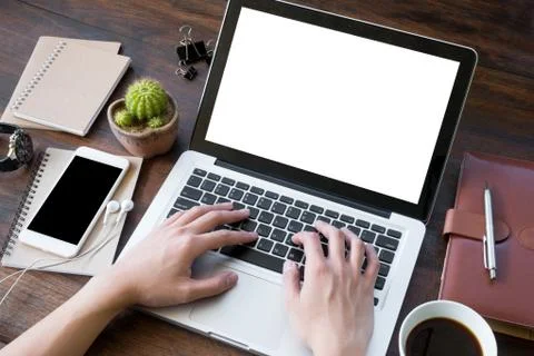 A man is working by using a laptop computer on vintage wooden table. Stock Photos