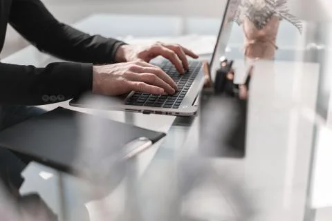 Man working by using a laptop computer on wooden table. Hands ty Foto stock