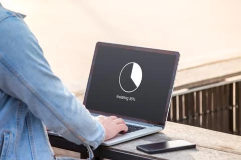 A man is working using laptop doing installing update with circle load percentag Stock Photos