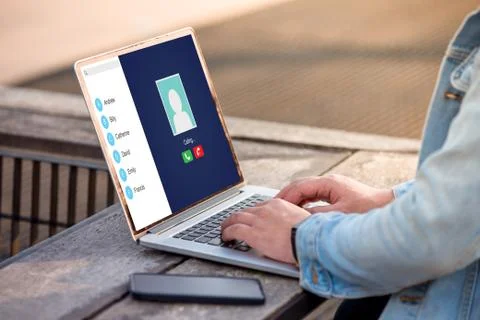 A man is working using laptop doing video call with her friend at outdoor Stock Photos