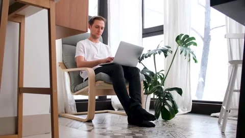 Man working using laptop at home while sitting in chair Stock Footage 167421852