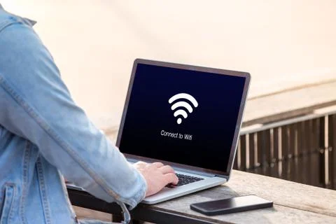 A man is working using laptop waiting for wi-fi connection on screen at outdoor Stock Photos