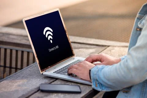 A man is working using laptop waiting for wi-fi connection on screen at outdoor Stock Photos