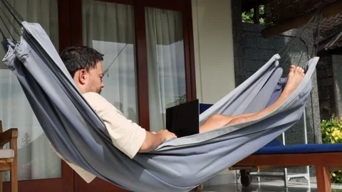 Man working on vacation lying on the hammock outdoors. Tropical holiday. Stock Footage 160902009